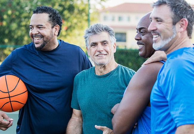 four middle-aged men playing basketball